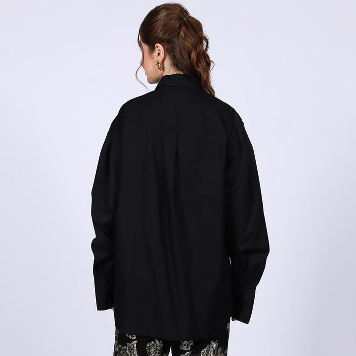 Back view of a woman wearing a black cotton rhinestone-embellished shirt.