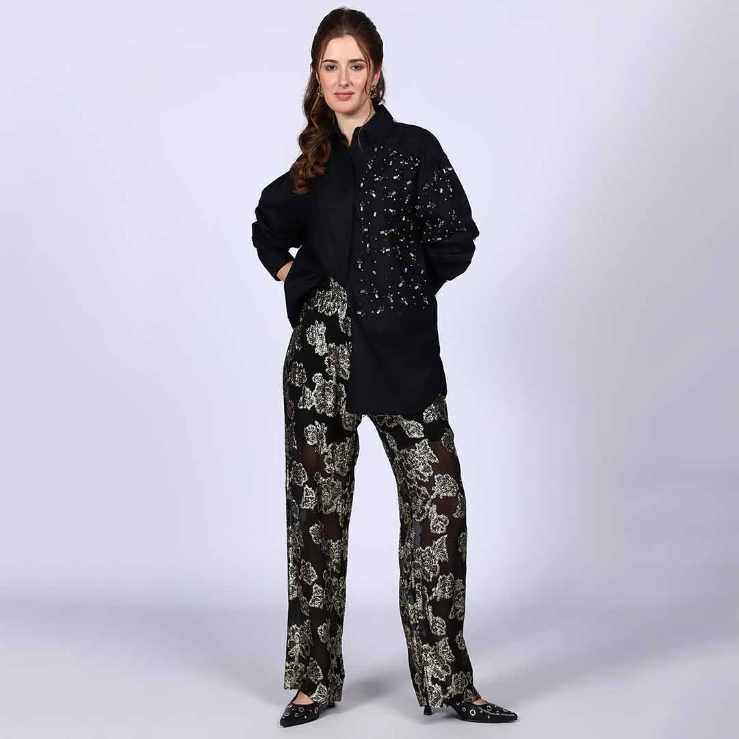 Woman wearing a black cotton shirt with rhinestone and pearl embellishment on the collar.