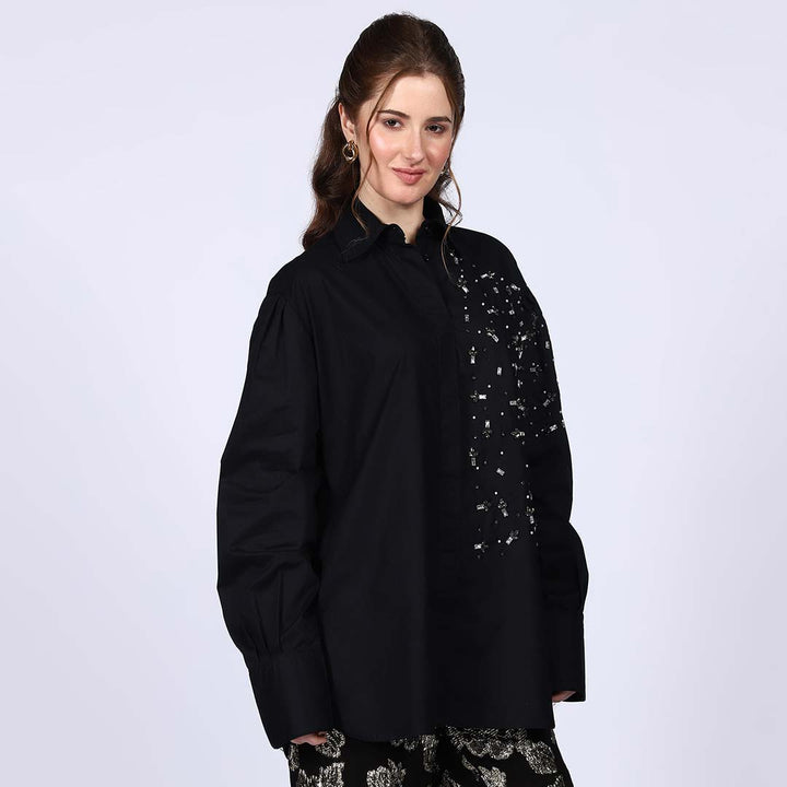 Full-length shot of a woman wearing a black cotton rhinestone shirt.