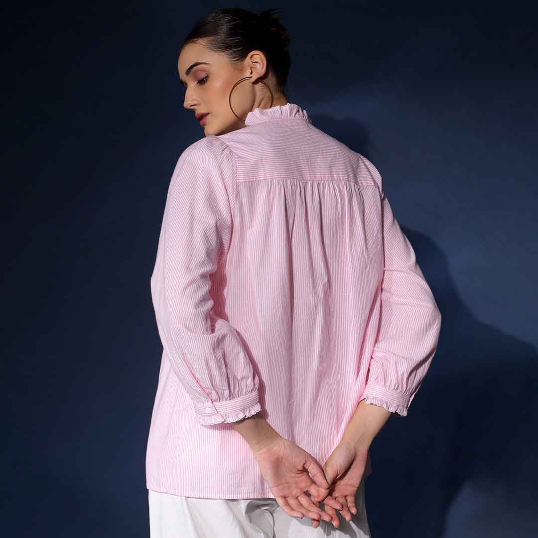 Back view of a woman wearing a blush yarn-dyed striped cotton top.