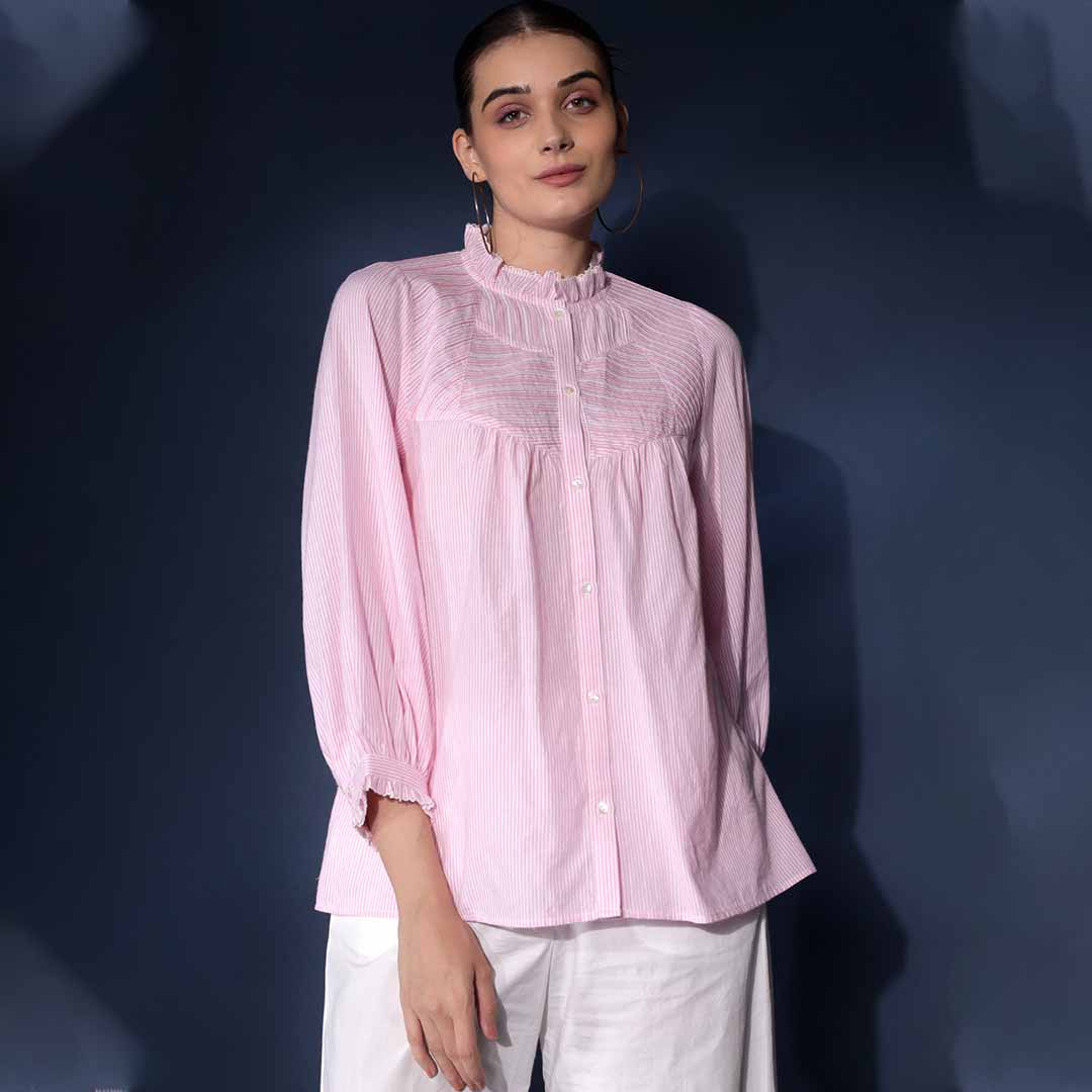 Woman wearing a soft pink yarn-dyed striped cotton top.
