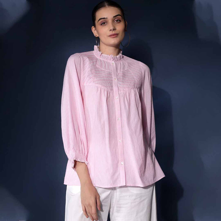 Woman wearing a soft pink yarn-dyed striped cotton top.