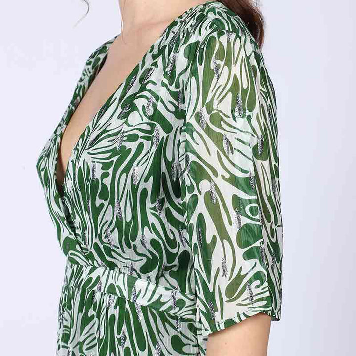 Woman wearing a green abstract-print mini dress, walking.