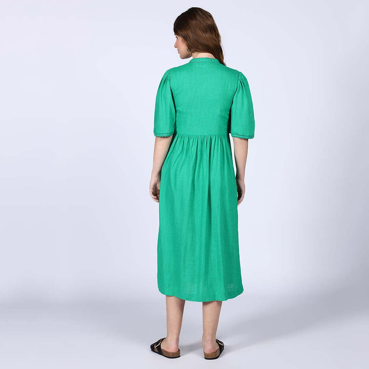 Back view of a woman wearing a green cotton midi dress.