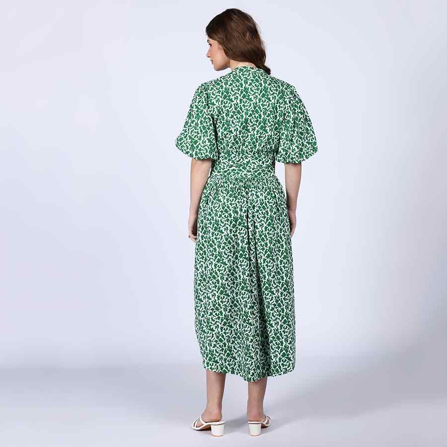 Back view of a woman wearing a green floral-print cotton midi dress.