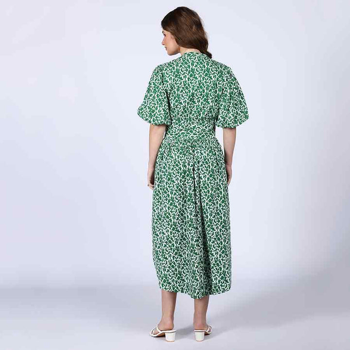 Back view of a woman wearing a green floral-print cotton midi dress.