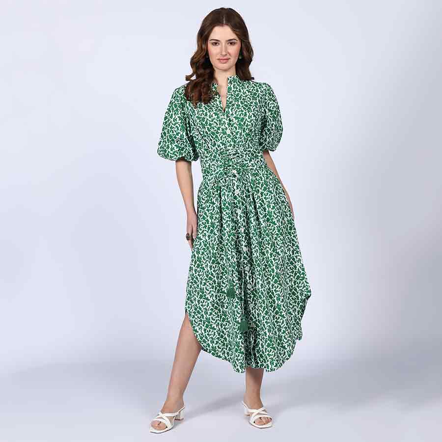 Woman wearing a green floral-print cotton midi dress with puff sleeves.