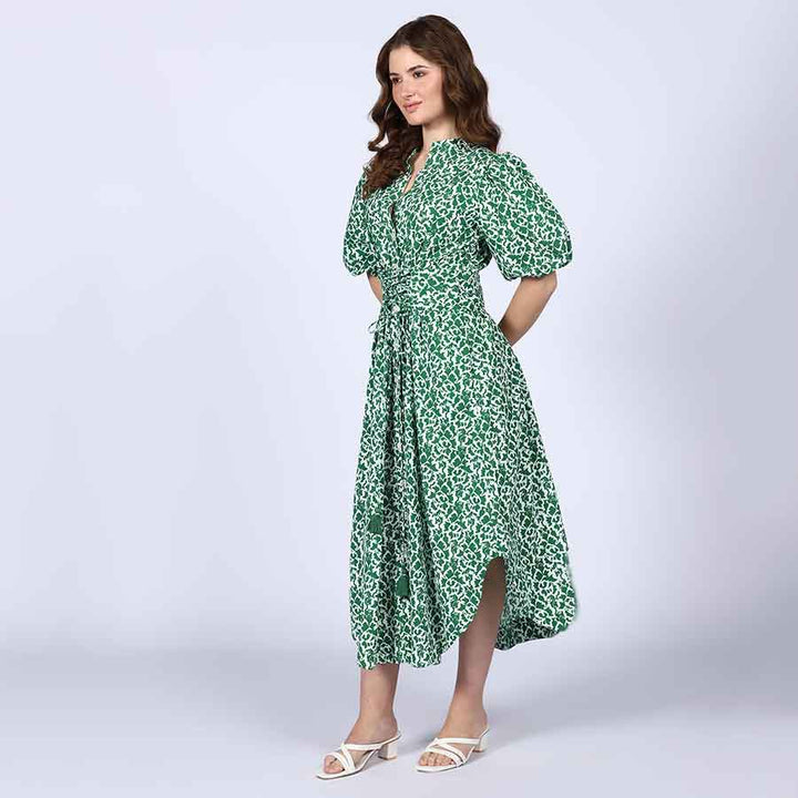 Alternate side view of a woman wearing a green floral-print cotton dress.