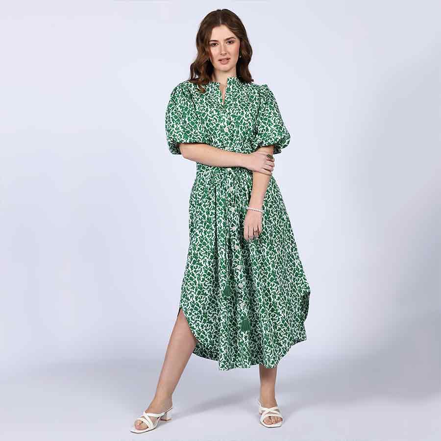 Side view of a woman wearing a green floral-print cotton dress.