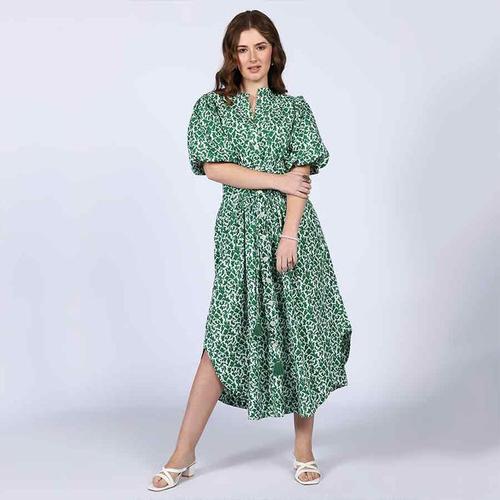 Side view of a woman wearing a green floral-print cotton dress.