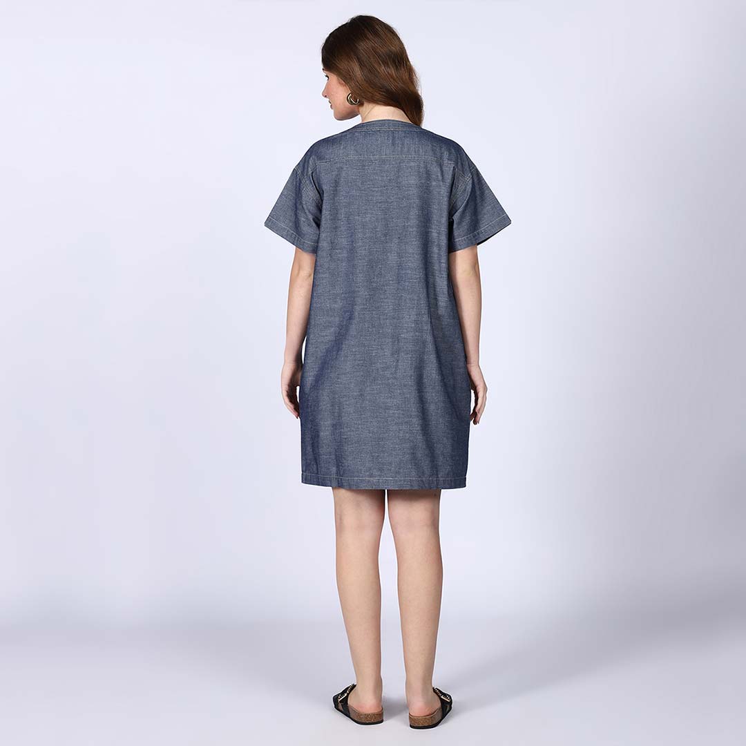 Back view of a woman wearing a grey chambray short dress.