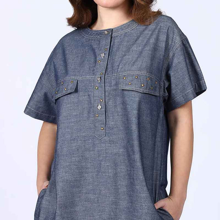 Close-up of the button placket and stud trim on a grey chambray dress.