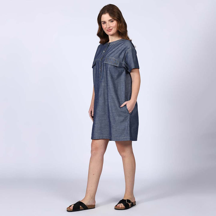 Side view of a woman wearing a grey chambray short dress.
