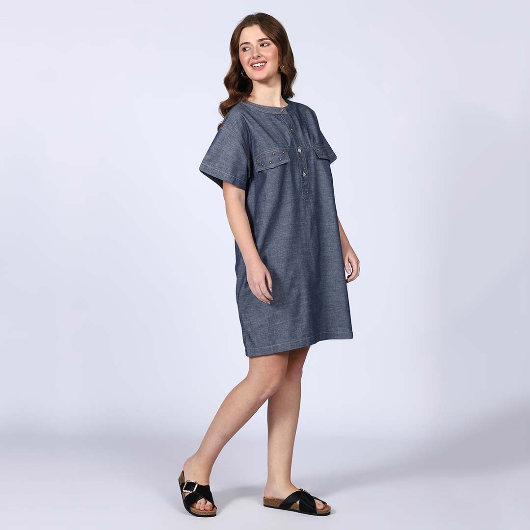 Woman wearing a grey chambray short dress, walking.
