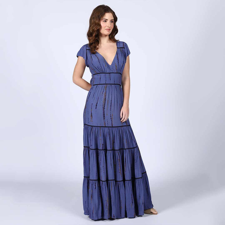 Close-up of the tie-dye print and tiered hem on an indigo viscose maxi dress.