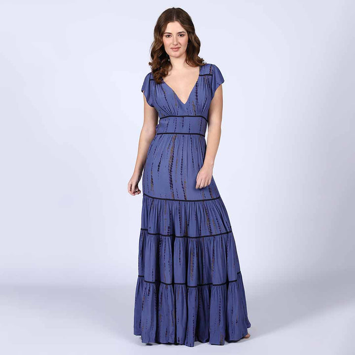 Woman wearing an indigo tie-dye-print tiered viscose maxi dress with a V-neck.