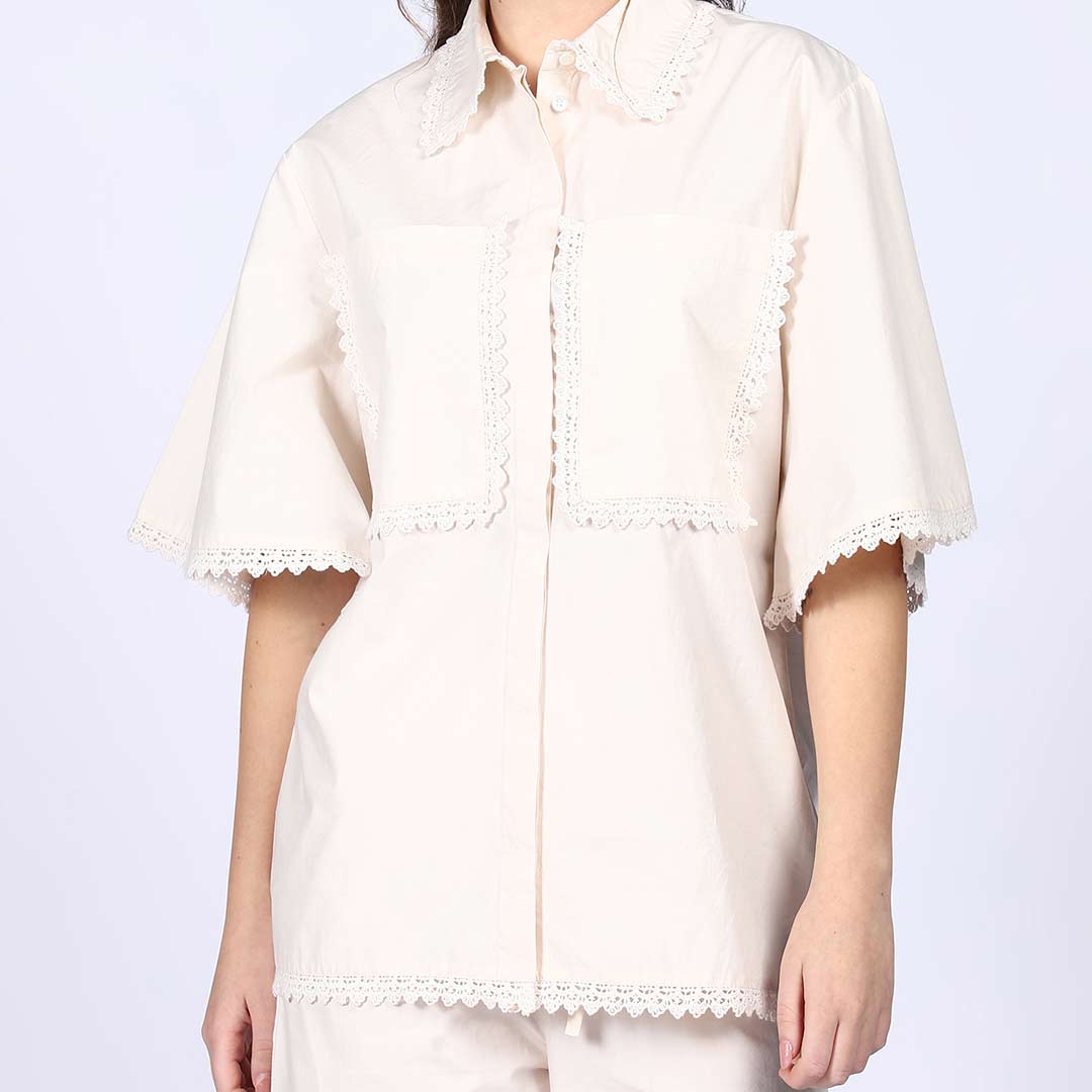 Close-up of the crochet trim on an ivory cotton co-ord set chest pocket and collar.