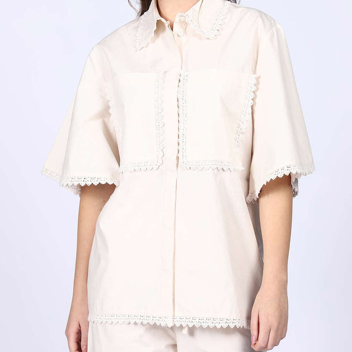 Close-up of the crochet trim on an ivory cotton co-ord set chest pocket and collar.