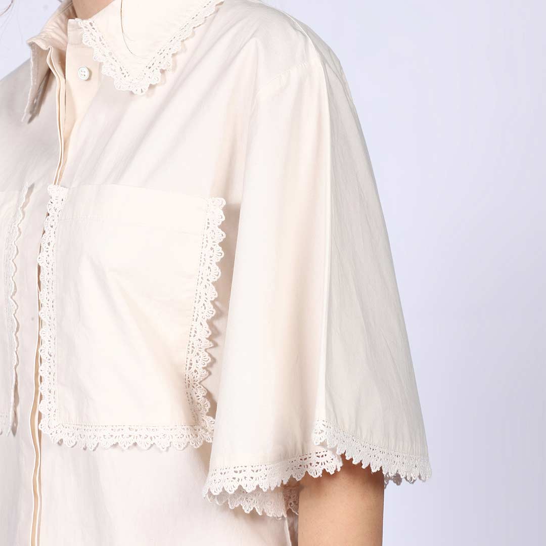 Detail shot of the lace trim and pocket on an ivory cotton poplin co-ord set.