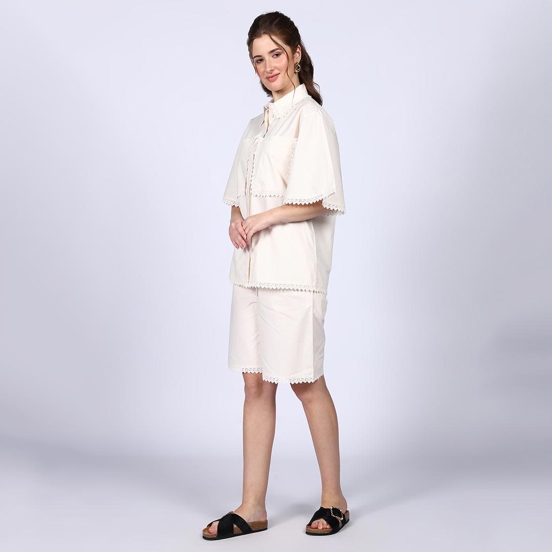 Full-length shot of a woman wearing an ivory cotton poplin co-ord set.