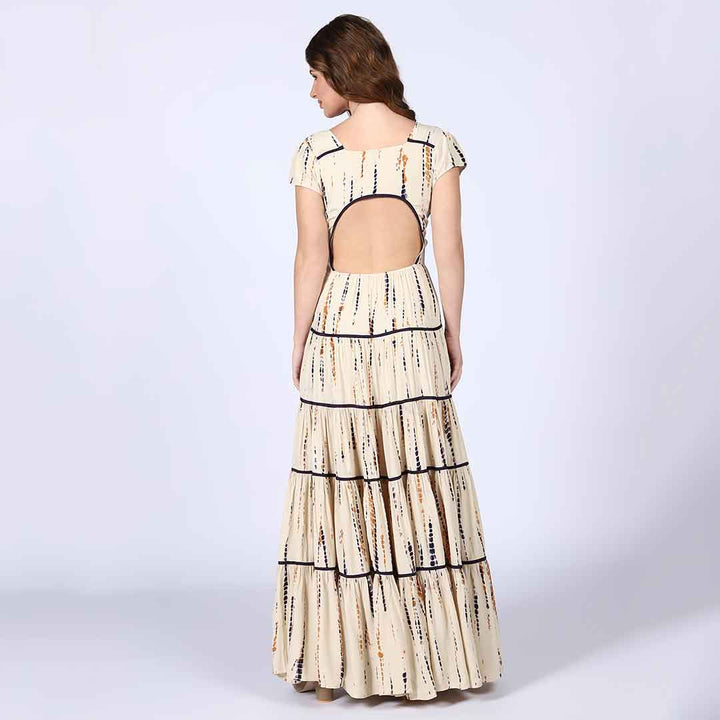 Back view of a woman wearing an ivory tiered viscose maxi dress.