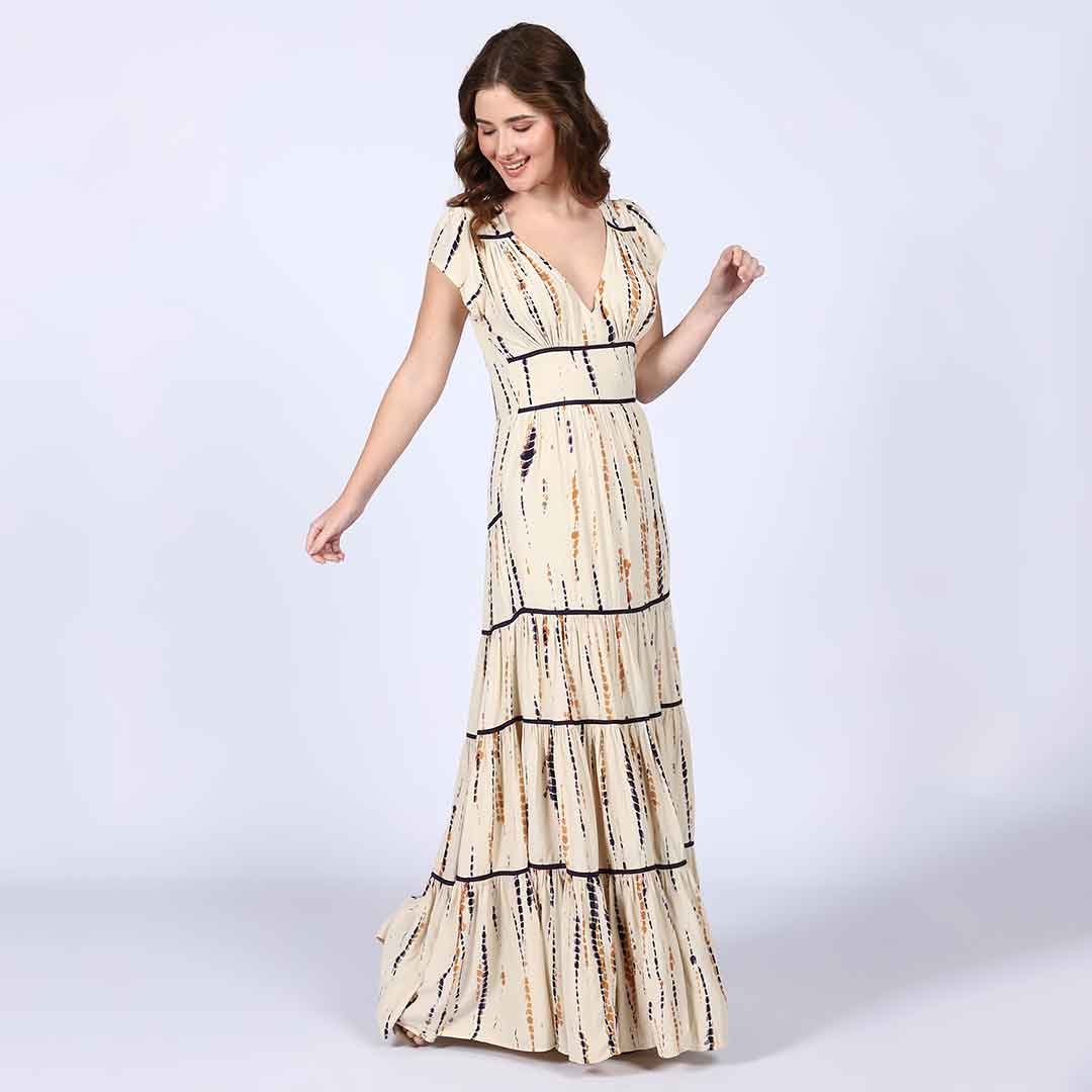 Full-length shot of a woman wearing an ivory tiered maxi dress.