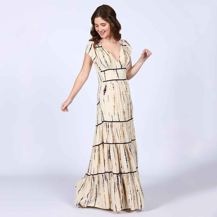Full-length shot of a woman wearing an ivory tiered maxi dress.