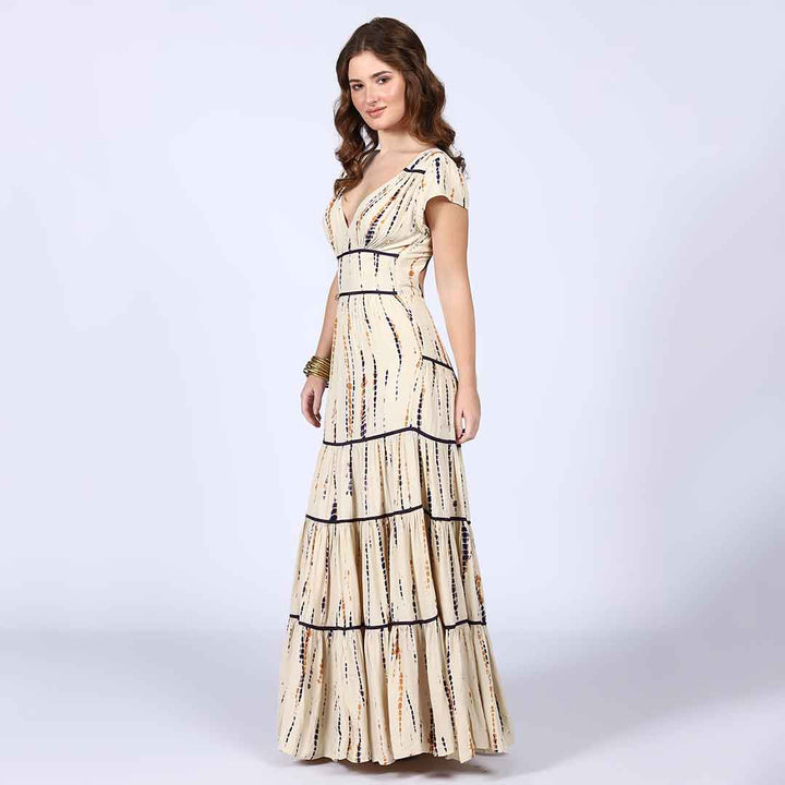 Side view of a woman wearing an ivory tiered maxi dress.
