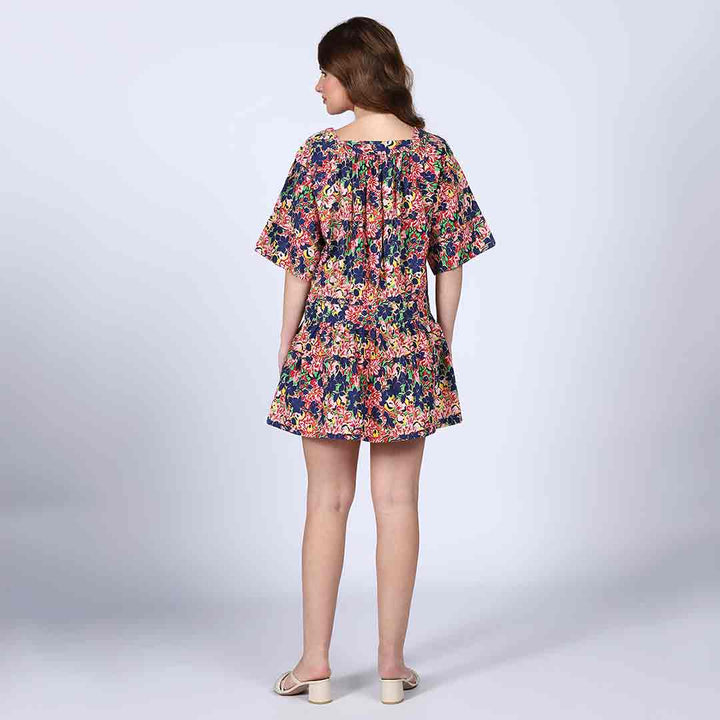 Back view of a woman wearing a multicolour floral-print short dress.