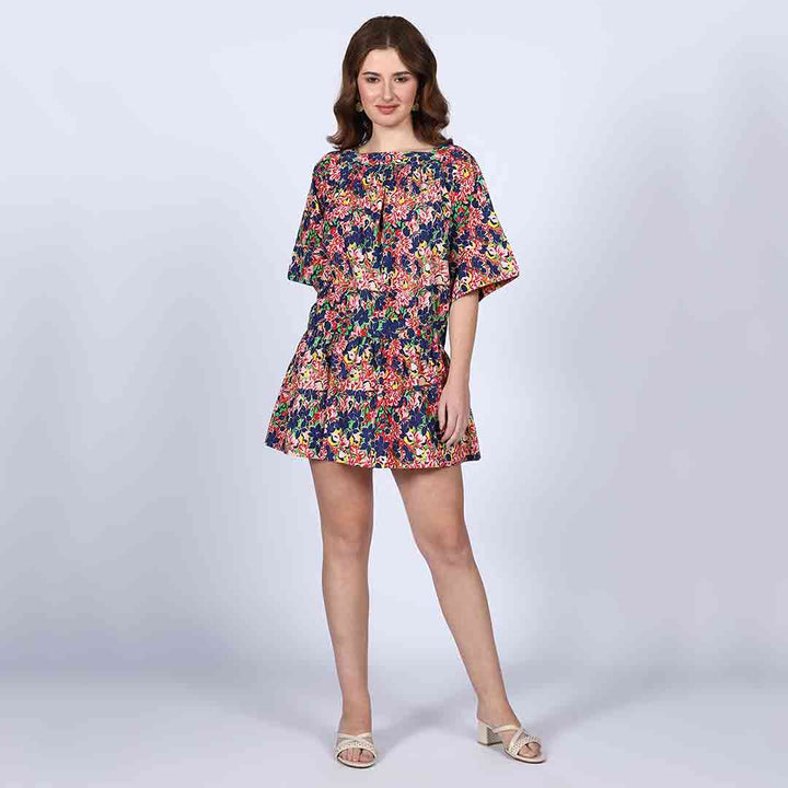 Woman wearing a multicolour floral-print short dress with dropped-shoulder sleeves.