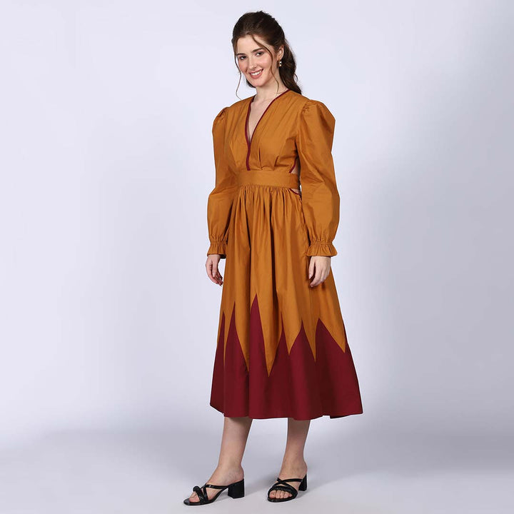 Front view of a woman wearing a mustard and burgundy colour-block dress.
