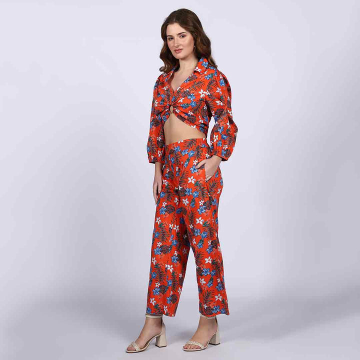 Close-up of the orange floral print on a cropped top and trousers co-ord.