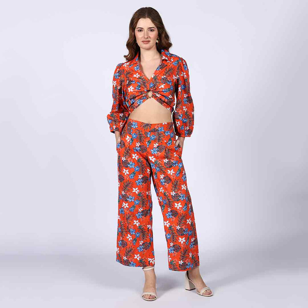 Full-length shot of a woman wearing an orange floral co-ord set.
