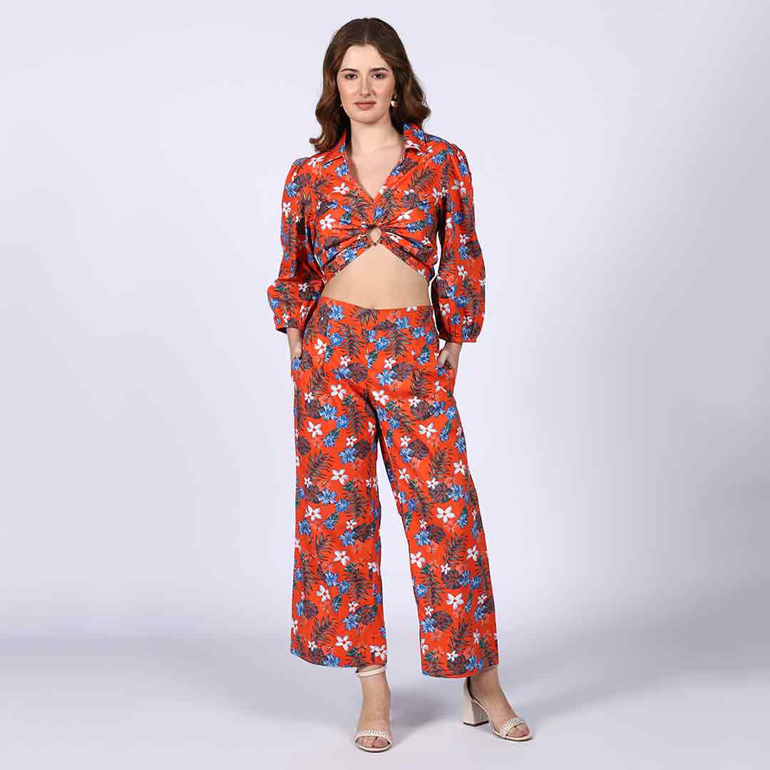 Full-length shot of a woman wearing an orange floral co-ord set.