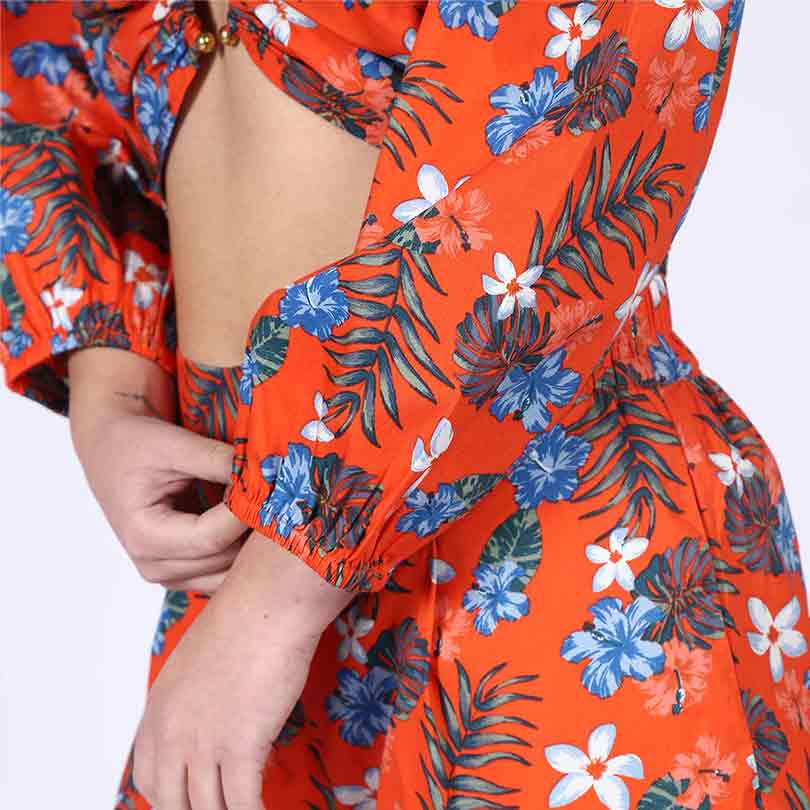 Close-up of the sleeve print and cutout waist on an orange floral co-ord top.