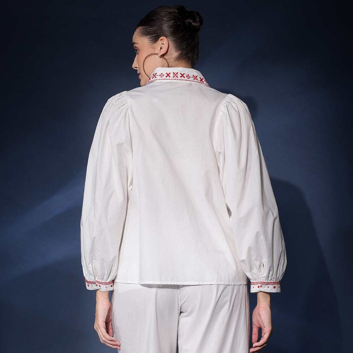 Back view of a woman wearing a white cotton shirt with embroidered collar.