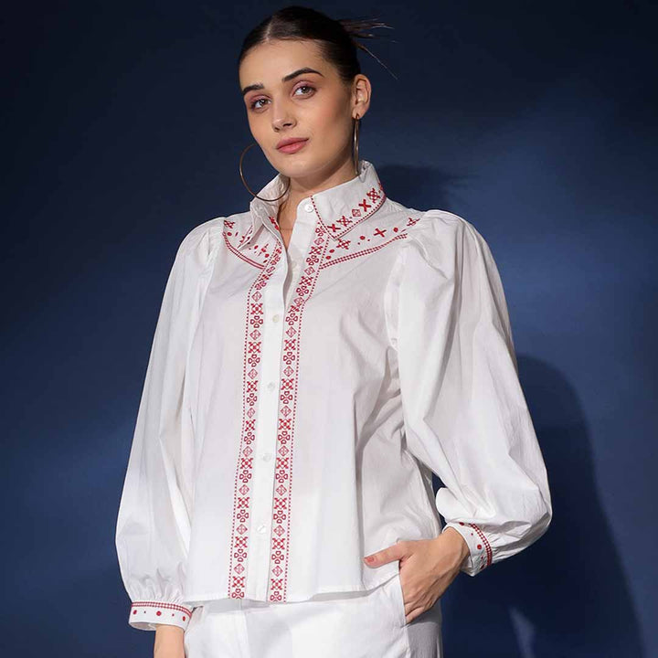 Side view of a woman wearing a white embroidered cotton shirt.