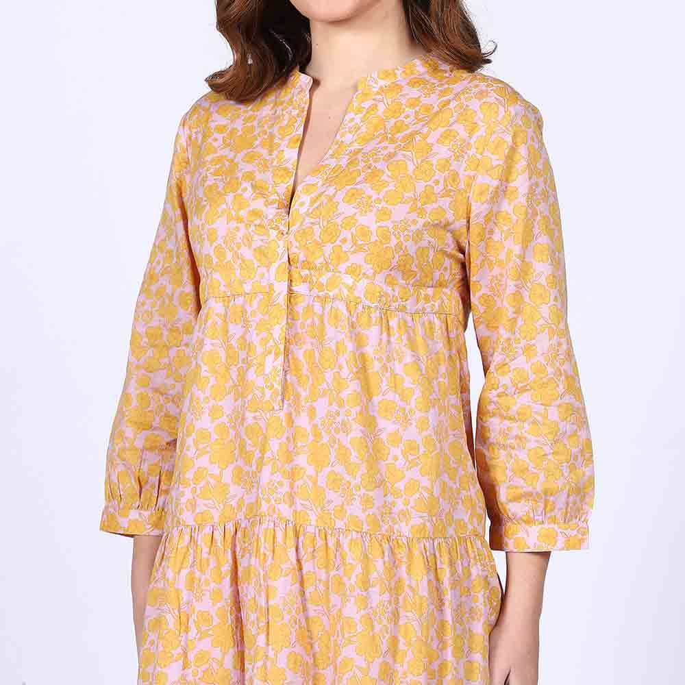 Detail shot of the tiered skirt on a yellow multicolour cotton midi dress.