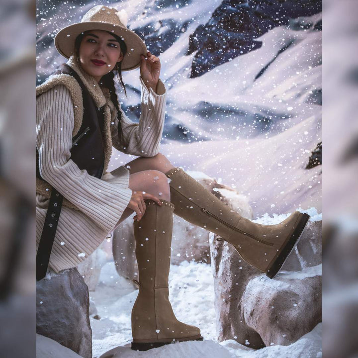Model wearing ladies ivory suede wedge boots in a winter setting
