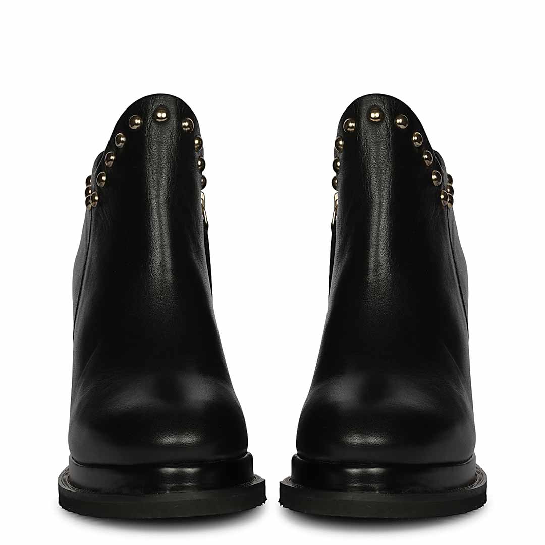 Pair of womens black studded leather wedge ankle boots, front view